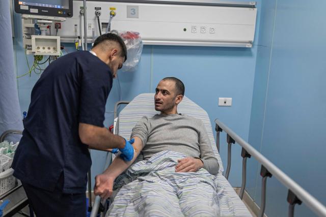 Palestinian Rabia Abu Naim is being treated by a doctor at a hospital following his release from Israeli prison in the Israeli occupied West Bank city of Ramallah on July 8, 2026. The number of Palestinian detainees in Israeli prisons stands at around 9,500, according to figures released in June by the Palestinian Prisoners Club, the main rights group for Palestinian prisoners. Since the start of the Gaza war in October 2023, violence has escalated in the Israeli-occupied West Bank. (Photo by ilia YEFIMOVICH / AFP)