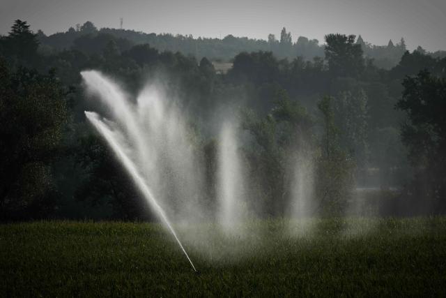 This photograph shows a hose reel irrigator spraying water over a maize field as a heatwave and drought strain agriculture in La Réole, south-western France, on July 8, 2026. (Photo by Philippe LOPEZ / AFP)