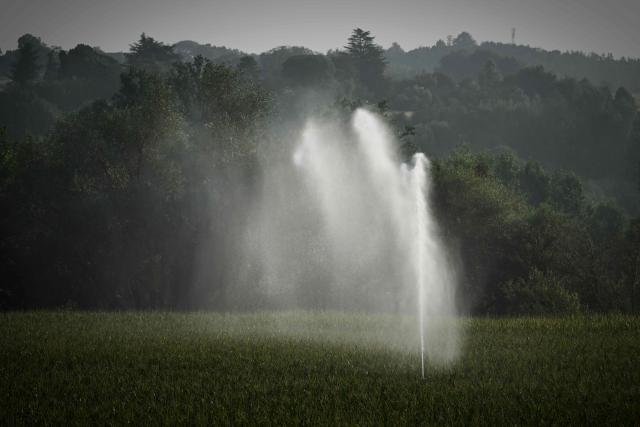 This photograph shows a hose reel irrigator spraying water over a maize field as a heatwave and drought strain agriculture in La Réole, south-western France, on July 8, 2026. (Photo by Philippe LOPEZ / AFP)