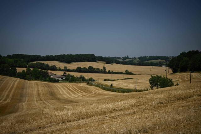 This photograph shows stubble fields and straw bales across rolling farmland after an early cereal harvest hastened by heatwave and drought near Ségalas,some 35kms from Marmande, south-western France, on July 8, 2026. (Photo by Philippe LOPEZ / AFP)