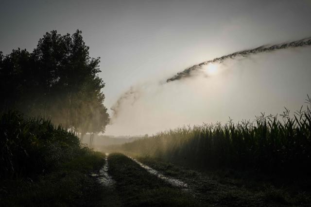 This photograph shows a hose reel irrigator spraying water over a maize field as a heatwave and drought strain agriculture in La Réole, south-western France, on July 8, 2026. (Photo by Philippe LOPEZ / AFP)