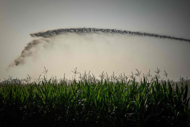 This photograph shows a hose reel irrigator spraying water over a maize field as a heatwave and drought strain agriculture in La Réole, south-western France, on July 8, 2026. (Photo by Philippe LOPEZ / AFP)