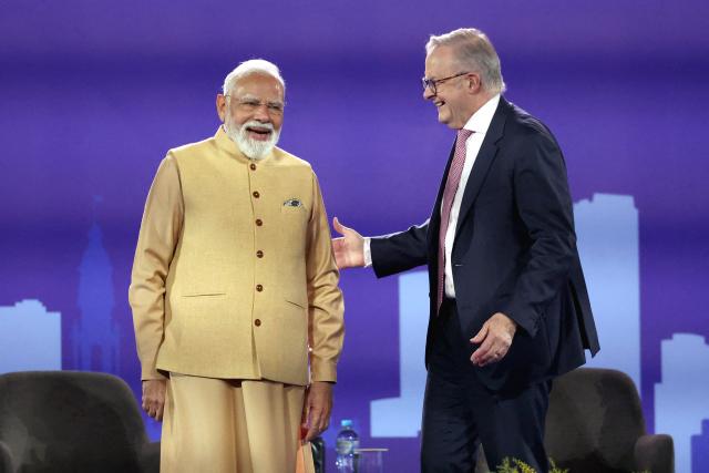 Australia’s Prime Minister Anthony Albanese (R) and Indian Prime Minister Narendra Modi react on stage during a community event at Docklands Stadium in Melbourne on July 9, 2026. (Photo by MARTIN KEEP / AFP)