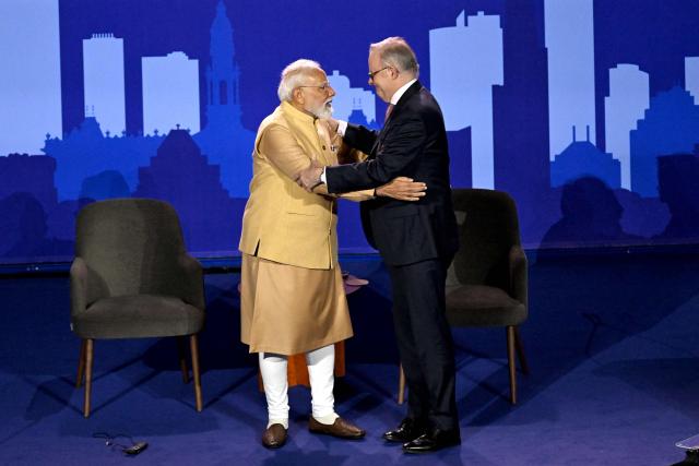 Australia’s Prime Minister Anthony Albanese (R) and Indian Prime Minister Narendra Modi greet each other on stage during a community event at Docklands Stadium in Melbourne on July 9, 2026. (Photo by WILLIAM WEST / AFP)