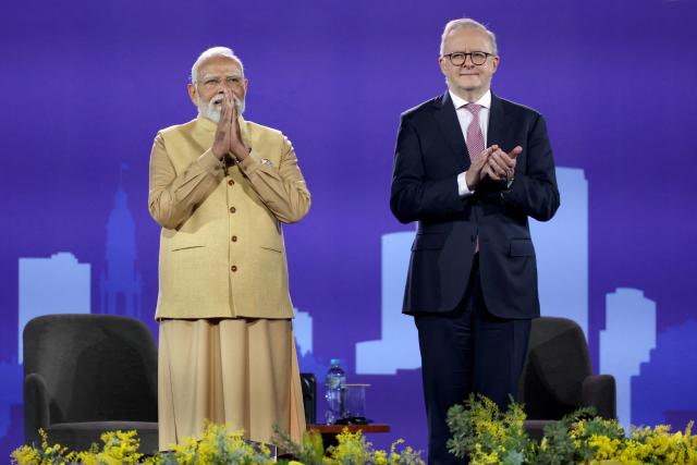 Australia’s Prime Minister Anthony Albanese (R) and Indian Prime Minister Narendra Modi react on stage during a community event at Docklands Stadium in Melbourne on July 9, 2026. (Photo by MARTIN KEEP / AFP)