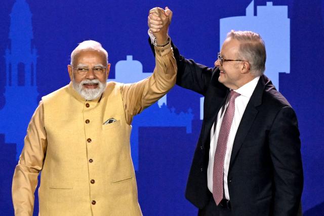 Australia’s Prime Minister Anthony Albanese (R) reacts with Indian Prime Minister Narendra Modi as they stand on stage during a community event at Docklands Stadium in Melbourne on July 9, 2026. (Photo by WILLIAM WEST / AFP)