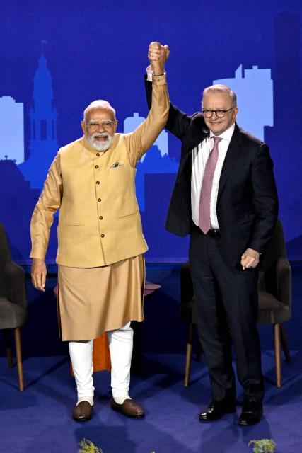 Australia’s Prime Minister Anthony Albanese (R) reacts with Indian Prime Minister Narendra Modi as they stand on stage during a community event at Docklands Stadium in Melbourne on July 9, 2026. (Photo by WILLIAM WEST / AFP)