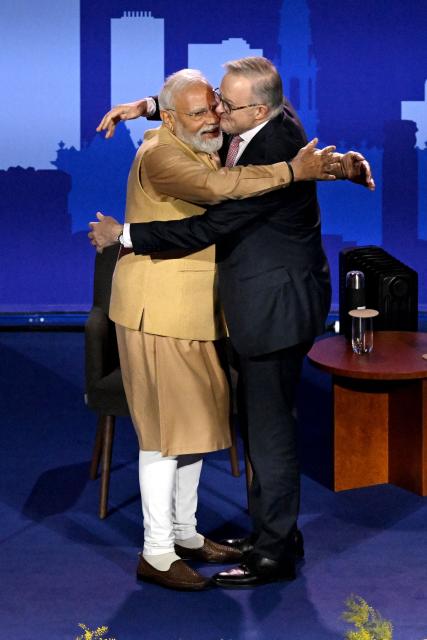 Australia’s Prime Minister Anthony Albanese (R) embraces Indian Prime Minister Narendra Modi as they stand on stage during a community event at Docklands Stadium in Melbourne on July 9, 2026. (Photo by WILLIAM WEST / AFP)