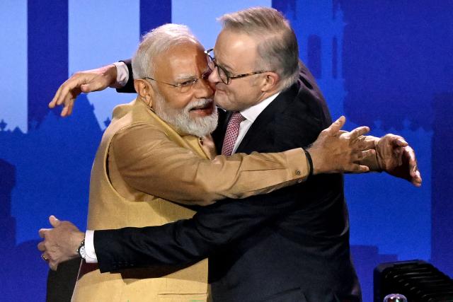 Australia’s Prime Minister Anthony Albanese (R) embraces Indian Prime Minister Narendra Modi as they stand on stage during a community event at Docklands Stadium in Melbourne on July 9, 2026. (Photo by WILLIAM WEST / AFP)