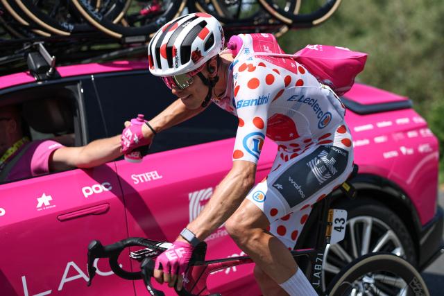 EF Education - EasyPost team's French rider Alex Baudin wearing the climber's dotted "King of the Mountains" jersey collects hydration bottles at his team vehicle as he cycles during the 6th stage of the 113th edition of the Tour de France cycling race, 186,2 km between Pau and Gavarnie-Gèdre in the French Pyrenees, on July 9, 2026. (Photo by Anne-Christine POUJOULAT / AFP)