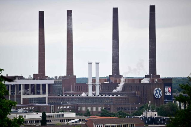 A general view taken on July 9, 2026 shows chimneys and buildings at the Wolfsburg Volkswagen (VW) Plant in Wolfsburg, Germany, prior to a planned rally of VW employees called by German trade union IG Metall to protest against restructuring and mass job cut plans at the VW headquarters in Wolfsburg, Germany. IG Metall is organising protests by VW workers outside plants across the country on July 9, when the carmaker's bosses will present the restructuring plans to the supervisory board. Europe's largest carmaker has come under intense pressure from US tariffs, slimmer profit margins from electric cars and above all intense competition in China, the world's largest auto market. VW, whose 10 brands range from mass-market Seats to premium Porsches, is already in the process of axing 50,000 jobs in Germany by 2030, including 35,000 at its namesake marque. (Photo by Tobias SCHWARZ / AFP)