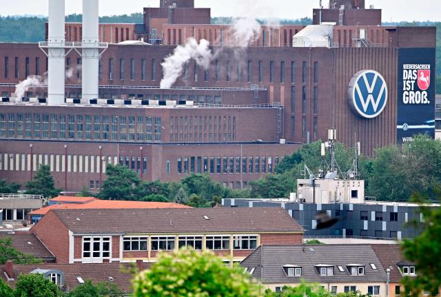 A general view taken on July 9, 2026 shows chimneys and buildings at the Wolfsburg Volkswagen (VW) Plant in Wolfsburg, Germany, prior to a planned rally of VW employees called by German trade union IG Metall to protest against restructuring and mass job cut plans at the VW headquarters in Wolfsburg, Germany. IG Metall is organising protests by VW workers outside plants across the country on July 9, when the carmaker's bosses will present the restructuring plans to the supervisory board. Europe's largest carmaker has come under intense pressure from US tariffs, slimmer profit margins from electric cars and above all intense competition in China, the world's largest auto market. VW, whose 10 brands range from mass-market Seats to premium Porsches, is already in the process of axing 50,000 jobs in Germany by 2030, including 35,000 at its namesake marque. (Photo by Tobias SCHWARZ / AFP)