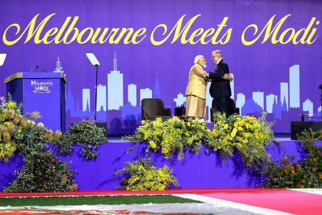 Australia’s Prime Minister Anthony Albanese (R) and Indian Prime Minister Narendra hold each other on stage during a community event at Docklands Stadium in Melbourne on July 9, 2026. (Photo by MARTIN KEEP / AFP)