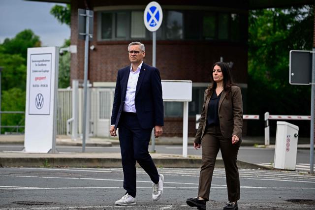 Daniela Cavallo (R), chairwoman of the central works council of German car maker Volkswagen (VW) and Thorsten Groeger of German trade union IG Metall arrive to addresses journalists at a rally to protest against restructuring and mass job cut plans at the VW headquarters on July 9, 2026 at the Wolfsburg Volkswagen Plant in Wolfsburg, northern Germany. IG Metall is organising protests by VW workers outside plants across the country on July 9, when the carmaker's bosses will present the restructuring plans to the supervisory board. Europe's largest carmaker has come under intense pressure from US tariffs, slimmer profit margins from electric cars and above all intense competition in China, the world's largest auto market. VW, whose 10 brands range from mass-market Seats to premium Porsches, is already in the process of axing 50,000 jobs in Germany by 2030, including 35,000 at its namesake marque. (Photo by Tobias SCHWARZ / AFP)