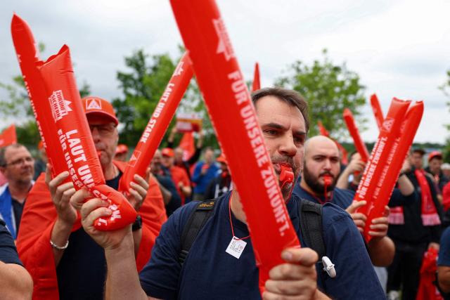 Volkswagen (VW) employees attend a rally to protest against restructuring and mass job cut plans at the VW headquarters on July 9, 2026 at the Wolfsburg Volkswagen Plant in Wolfsburg, northern Germany. IG Metall is organising protests by VW workers outside plants across the country on July 9, when the carmaker's bosses will present the restructuring plans to the supervisory board. Europe's largest carmaker has come under intense pressure from US tariffs, slimmer profit margins from electric cars and above all intense competition in China, the world's largest auto market. VW, whose 10 brands range from mass-market Seats to premium Porsches, is already in the process of axing 50,000 jobs in Germany by 2030, including 35,000 at its namesake marque. (Photo by Lisi Niesner / POOL / AFP)