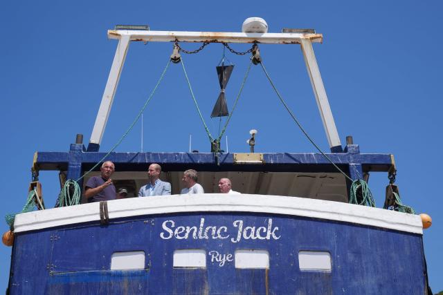 Britain's Prince William, Prince of Wales (2nd L), meets fishermen while on a fishing boat in the Old Town, during his visit to Hastings, south-east England on July 9, 2026, to highlight the town's fishing community and the vital work of local youth-led and community-driven organisations. (Photo by Gareth Fuller / POOL / AFP)