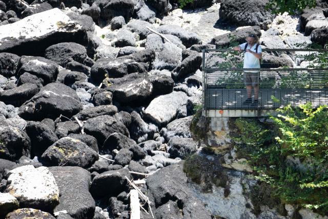 A hiker looks at the dry riverbed of the Doubs river at the 'saut du doubs' waterfall on July 9, 2026, in Villers-le-Lac, eastern France. (Photo by SEBASTIEN BOZON / AFP)