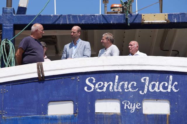 Britain's Prince William, Prince of Wales (3rd R), meets fishermen while on a fishing boat in the Old Town, during his visit to Hastings, south-east England on July 9, 2026, to highlight the town's fishing community and the vital work of local youth-led and community-driven organisations. (Photo by Gareth Fuller / POOL / AFP)