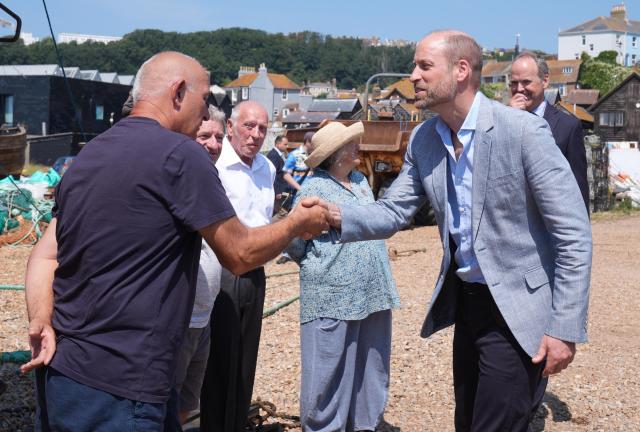Britain's Prince William, Prince of Wales (R), meets fishermen in the Old Town, during his visit to Hastings, south-east England on July 9, 2026, to highlight the town's fishing community and the vital work of local youth-led and community-driven organisations. (Photo by Gareth Fuller / POOL / AFP)