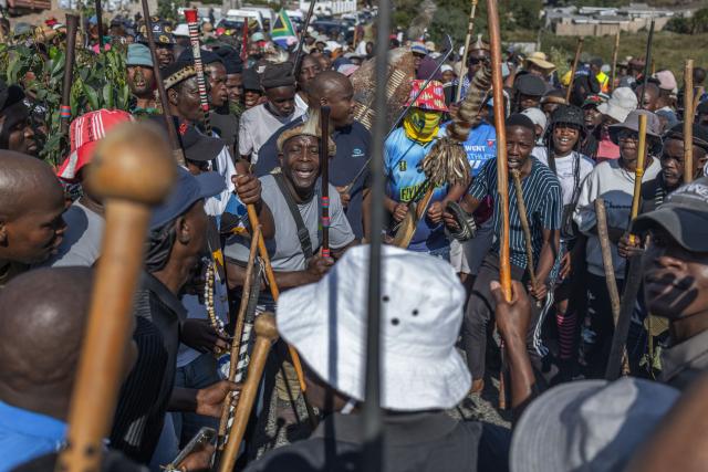 Protestors with traditional attire chant slogans during a demonstration by the "March and March" movement in Mtwalume, south of Durban, on July 9, 2026. The group previously held nationwide marches on June 30, 2026, and has called on its supporters to continue demonstrating every Thursday. The movement is calling on the government to enforce tougher measures against illegal immigration and to deport undocumented foreign nationals. The protests comes amid broader national discussions on border security, law enforcement, economic pressures, and South Africa's approach to immigration. (Photo by RAJESH JANTILAL / AFP)