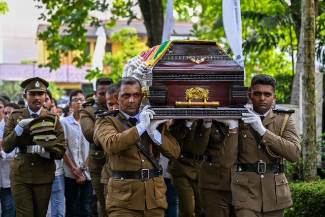 Officers carry the coffin of prison jailer S.H.G. Chandrawansha, killed in Negombo prison riot, during his funeral ceremony in Colombo on July 9, 2026. Sri Lanka launched an investigation on July 7 into its deadliest prison riot in years, as the death toll from clashes between rival drug gangs rose to 27. (Photo by Ishara S. KODIKARA / AFP)