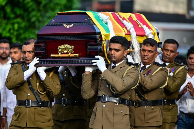 Officers carry the coffin of prison jailer S.H.G. Chandrawansha, killed in Negombo prison riot, during his funeral ceremony in Colombo on July 9, 2026. Sri Lanka launched an investigation on July 7 into its deadliest prison riot in years, as the death toll from clashes between rival drug gangs rose to 27. (Photo by Ishara S. KODIKARA / AFP)