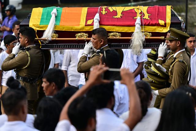 Officers carry the coffin of prison jailer S.H.G. Chandrawansha, killed in Negombo prison riot, during his funeral ceremony in Colombo on July 9, 2026. Sri Lanka launched an investigation on July 7 into its deadliest prison riot in years, as the death toll from clashes between rival drug gangs rose to 27. (Photo by Ishara S. KODIKARA / AFP)