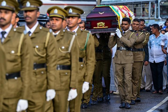 Officers carry the coffin of prison jailer S.H.G. Chandrawansha, killed in Negombo prison riot, during his funeral ceremony in Colombo on July 9, 2026. Sri Lanka launched an investigation on July 7 into its deadliest prison riot in years, as the death toll from clashes between rival drug gangs rose to 27. (Photo by Ishara S. KODIKARA / AFP)