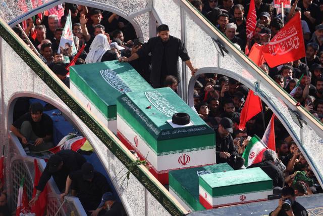 Crowds of mourners surround the convoy carrying the coffins of Iran's slain supreme leader Ali Khamenei and members of his family during a funeral procession, before he is buried at the Shrine of Imam Reza, Iran's most revered place of worship, in Mashhad on July 9, 2026. Braving sweltering heat and calling for revenge, Iranians loyal to the Islamic republic massed on July 9 for the burial of slain supreme leader Ali Khamenei in his hometown of Mashhad. (Photo by ATTA KENARE / AFP) / 