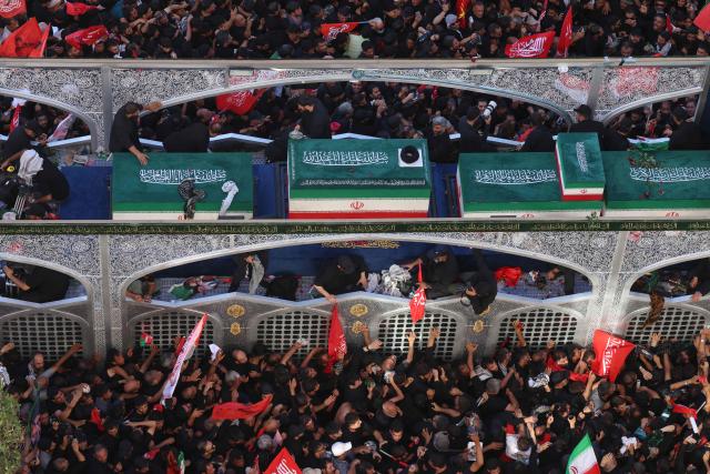 Crowds of mourners surround the convoy carrying the coffins of Iran's slain supreme leader Ali Khamenei and members of his family during a funeral procession, before he is buried at the Shrine of Imam Reza, Iran's most revered place of worship, in Mashhad on July 9, 2026. Braving sweltering heat and calling for revenge, Iranians loyal to the Islamic republic massed on July 9 for the burial of slain supreme leader Ali Khamenei in his hometown of Mashhad. (Photo by ATTA KENARE / AFP) / 