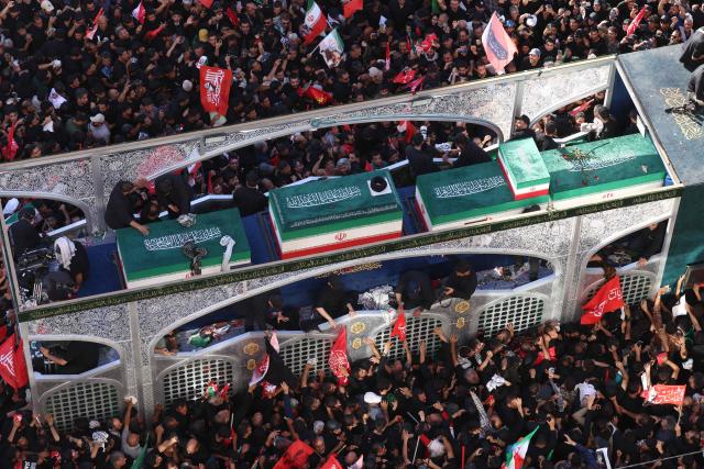 Crowds of mourners surround the convoy carrying the coffins of Iran's slain supreme leader Ali Khamenei and members of his family during a funeral procession, before he is buried at the Shrine of Imam Reza, Iran's most revered place of worship, in Mashhad on July 9, 2026. Braving sweltering heat and calling for revenge, Iranians loyal to the Islamic republic massed on July 9 for the burial of slain supreme leader Ali Khamenei in his hometown of Mashhad. (Photo by ATTA KENARE / AFP) / 