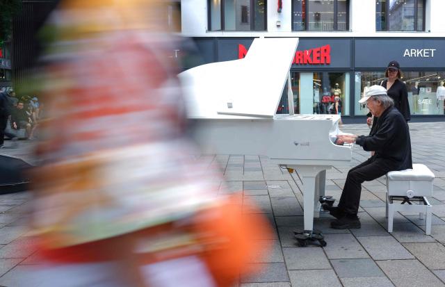Music professor of Fukuoka University Fukuda Nobumitsu who lives in Vienna, plays a piano free to play for everybody at Mariahilfer street in Vienna, Austria, on July 09, 2026. (Photo by Joe KLAMAR / AFP)