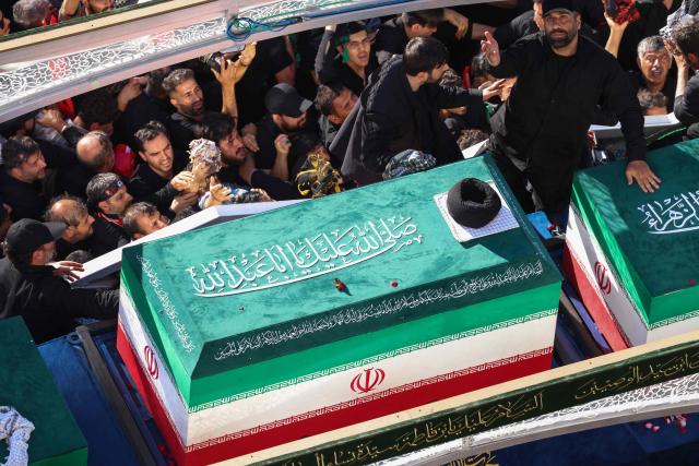 Crowds of mourners surround the convoy carrying the coffins of Iran's slain supreme leader Ali Khamenei and members of his family during a funeral procession, before he is buried at the Shrine of Imam Reza, Iran's most revered place of worship, in Mashhad on July 9, 2026. Braving sweltering heat and calling for revenge, Iranians loyal to the Islamic republic massed on July 9 for the burial of slain supreme leader Ali Khamenei in his hometown of Mashhad. (Photo by ATTA KENARE / AFP) / 