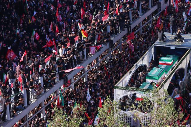 Crowds of mourners surround the convoy carrying the coffins of Iran's slain supreme leader Ali Khamenei and members of his family during a funeral procession, before he is buried at the Shrine of Imam Reza, Iran's most revered place of worship, in Mashhad on July 9, 2026. Braving sweltering heat and calling for revenge, Iranians loyal to the Islamic republic massed on July 9 for the burial of slain supreme leader Ali Khamenei in his hometown of Mashhad. (Photo by ATTA KENARE / AFP) / 