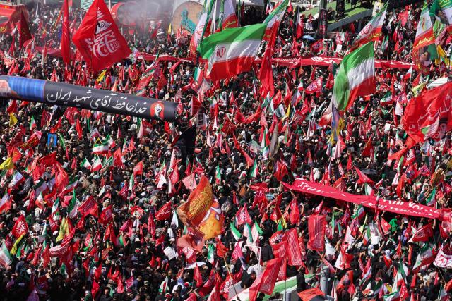Mourners march with flags and banners during a funeral procession for Iran's slain supreme leader Ali Khamenei and members of his family, before he is buried at the Shrine of Imam Reza, Iran's most revered place of worship, in Mashhad on July 9, 2026. Braving sweltering heat and calling for revenge, Iranians loyal to the Islamic republic massed on July 9 for the burial of slain supreme leader Ali Khamenei in his hometown of Mashhad. (Photo by ATTA KENARE / AFP) / 