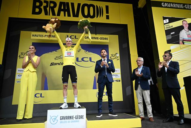 France's President Emmanuel Macron (R) applauds as UAE Team Emirates - XRG's Slovenian rider Tadej Pogacar celebrates on the podium with the overall leader's yellow jersey after the 6th stage of the 113th edition of the Tour de France cycling race, 186 km between Pau and Gavarnie-Gèdre in the French Pyrenees, on July 9, 2026. (Photo by Loic VENANCE / AFP)