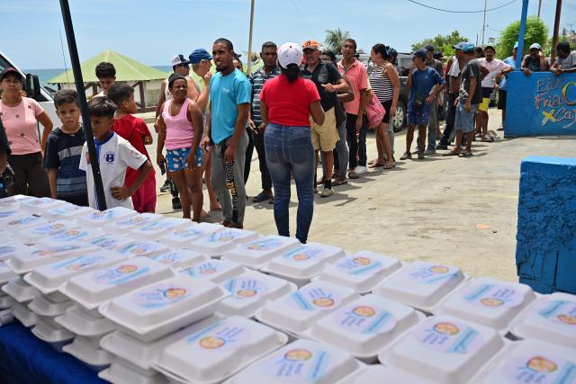 People queue to get a meal from NGO World Central Kitchen in Playa Grande, Catia La Mar, La Guaira State, Venezuela on July 9, 2026, following the June 24 twin earthquakes. The United Nations launched an urgent appeal on July 8, 2026 for nearly $300 million towards Venezuela earthquake relief operations as the death toll from the disaster rose to more than 3,800 people. (Photo by MARTIN BERNETTI / AFP)