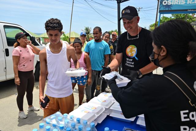 People queue to get a meal from NGO World Central Kitchen in Playa Grande, Catia La Mar, La Guaira State, Venezuela on July 9, 2026, following the June 24 twin earthquakes. The United Nations launched an urgent appeal on July 8, 2026 for nearly $300 million towards Venezuela earthquake relief operations as the death toll from the disaster rose to more than 3,800 people. (Photo by MARTIN BERNETTI / AFP)
