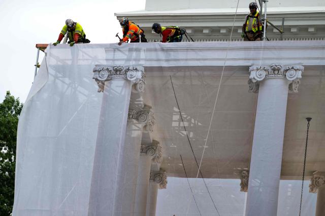 Workers place a protective cover over scaffolding surrounding the North Portico of the White House in Washington, DC on July 9, 2026. (Photo by Kent Nishimura / AFP)