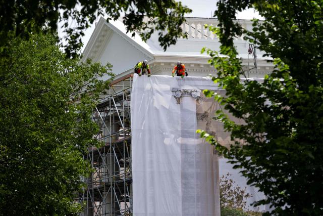 Workers place a protective cover over scaffolding surrounding the North Portico of the White House in Washington, DC on July 9, 2026. (Photo by Kent Nishimura / AFP)