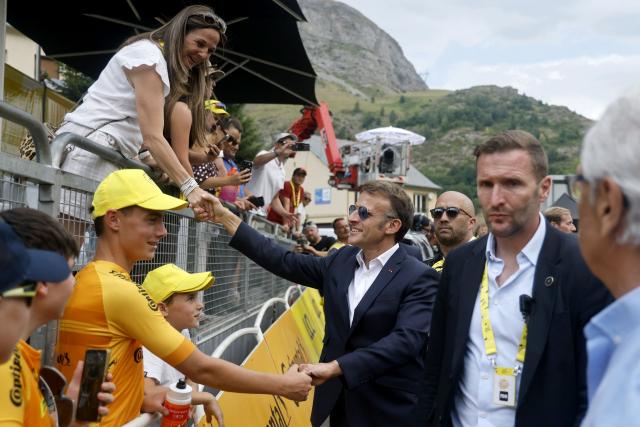 France's President Emmanuel Macron shakes hands with spectators at the finish are of the 6th stage of the 113th edition of the Tour de France cycling race, 186 km between Pau and Gavarnie-Gèdre in the French Pyrenees, on July 9, 2026. (Photo by Guillaume HORCAJUELO / POOL / AFP)