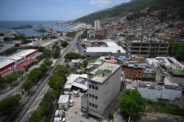 This aerial view shows the port of La Guaira where US' amphibious transport dock ships (background) USS San Antonio (LPD-17) (L) and USS Fort Lauderdale (LPD-28) remain docked, state of La Guaira, Venezuela, on July 9, 2026, following the June 24 twin earthquakes. The United Nations launched an urgent appeal on July 8, 2026 for nearly $300 million towards Venezuela earthquake relief operations as the death toll from the disaster rose to more than 3,800 people. (Photo by Raul ARBOLEDA / AFP)