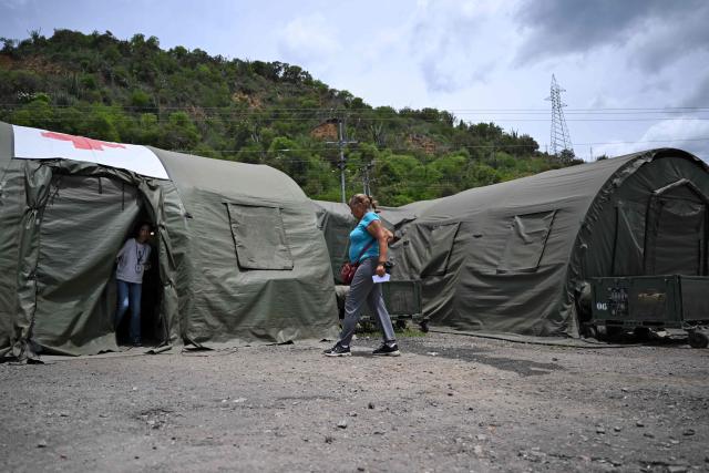 A woman walks at Brazil's military field hospital in Camuri Chico, near Macuto, La Guaira State, Venezuela on July 9, 2026, following the June 24 twin earthquakes. The United Nations launched an urgent appeal on July 8, 2026 for nearly $300 million towards Venezuela earthquake relief operations as the death toll from the disaster rose to more than 3,800 people. (Photo by Raul ARBOLEDA / AFP)