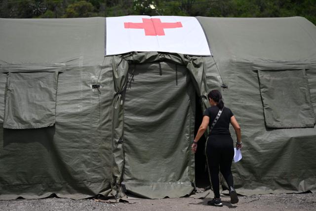 A woman enters a tent at Brazil's military field hospital in Camuri Chico, near Macuto, La Guaira State, Venezuela on July 9, 2026, following the June 24 twin earthquakes. The United Nations launched an urgent appeal on July 8, 2026 for nearly $300 million towards Venezuela earthquake relief operations as the death toll from the disaster rose to more than 3,800 people. (Photo by Raul ARBOLEDA / AFP)