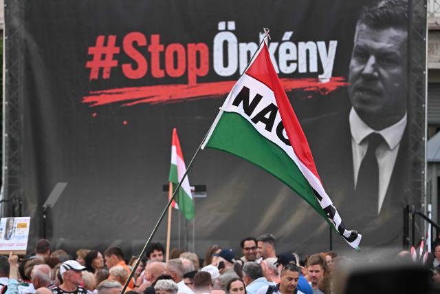 Protesters hold Hungarian flags as they attend a demonstration of supporters of the former government party-coalition Fidesz–KDNP (Fidesz – Hungarian Civic Alliance and the Christian Democratic People's Party (KDNP) with the motto 'Put an End to Arbitrariness!' in Budapest on July 09, 2026. According to the organisers, the aim of the demonstration is to protest against the 17th Amendment to the Fundamental Law initiated by the Tisza government, which would affect several public offices, including the position of President of the Republic Tamas Sulyok. (Photo by Attila KISBENEDEK / AFP)
