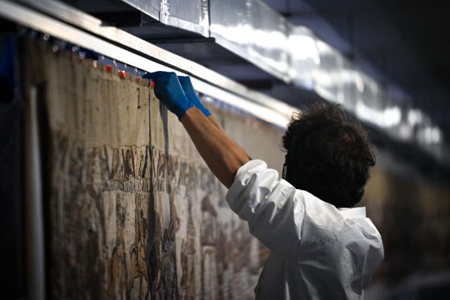 (FILES) A worker prepares to pack the Bayeux Tapestry in a crate for transfer to the British Museum, at the Bayeux Tapestry Museum, in Bayeux, northwestern France, on September 18, 2025. The medieval Bayeux Tapestry began a complicated journey from northern France to London on July 9, 2026, where the 11th-century artwork is set to go on display at the British Museum. The fragile 68-metre (224-foot) embroidered tapestry has left its home in Bayeux in a high-tech container designed to eliminate vibrations and maintain a steady temperature and humidity, the source said. (Photo by LOU BENOIST / POOL / AFP)