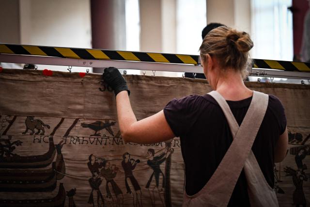 (FILES) A worker prepares to pack the Bayeux Tapestry in a crate for transfer to the British Museum, at the Bayeux Tapestry Museum, in Bayeux, northwestern France, on September 18, 2025. The medieval Bayeux Tapestry began a complicated journey from northern France to London on July 9, 2026, where the 11th-century artwork is set to go on display at the British Museum. The fragile 68-metre (224-foot) embroidered tapestry has left its home in Bayeux in a high-tech container designed to eliminate vibrations and maintain a steady temperature and humidity, the source said. (Photo by LOU BENOIST / POOL / AFP)