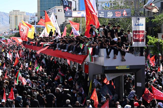 Crowds of mourners gather on a street ahead of the funeral procession of Iran's slain supreme leader Ali Khamenei and members of his family, before he is buried at the Shrine of Imam Reza, Iran's most revered place of worship, in Mashhad on July 9, 2026. Calling for revenge and rejecting any compromise with the West, Iranians loyal to the Islamic republic braved sweltering heat on July 9 to mass for the burial of supreme leader Ali Khamenei in his hometown of Mashhad. (Photo by Wakil Kohsar / AFP) / 