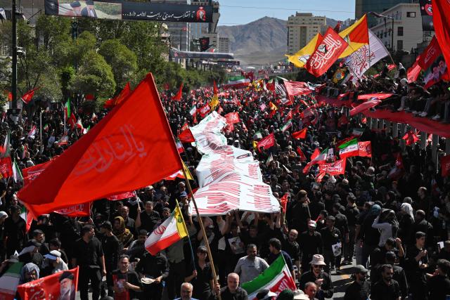 Crowds of mourners gather on a street ahead of the funeral procession of Iran's slain supreme leader Ali Khamenei and members of his family, before he is buried at the Shrine of Imam Reza, Iran's most revered place of worship, in Mashhad on July 9, 2026. Calling for revenge and rejecting any compromise with the West, Iranians loyal to the Islamic republic braved sweltering heat on July 9 to mass for the burial of supreme leader Ali Khamenei in his hometown of Mashhad. (Photo by Wakil Kohsar / AFP) / 
