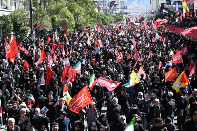 Crowds of mourners gather on a street ahead of the funeral procession of Iran's slain supreme leader Ali Khamenei and members of his family, before he is buried at the Shrine of Imam Reza, Iran's most revered place of worship, in Mashhad on July 9, 2026. Calling for revenge and rejecting any compromise with the West, Iranians loyal to the Islamic republic braved sweltering heat on July 9 to mass for the burial of supreme leader Ali Khamenei in his hometown of Mashhad. (Photo by Wakil Kohsar / AFP) / 